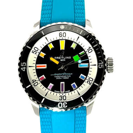 Breitling Superocean III Automatic 42 Rainbow Uhr mit türkisem Kautschukband und schwarzem Zifferblatt mit bunten Indizes.