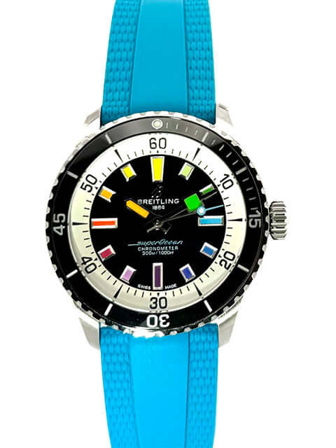 Breitling Superocean III Automatic 42 Rainbow Uhr mit türkisem Kautschukband und schwarzem Zifferblatt mit bunten Indizes.