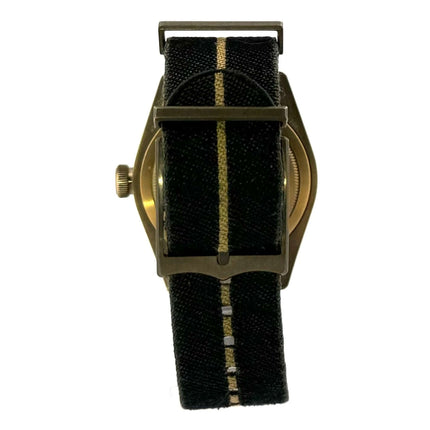 Rückansicht der Tudor Black Bay Bronze Uhr mit schwarzem Textilarmband und bronzenem Gehäuse.