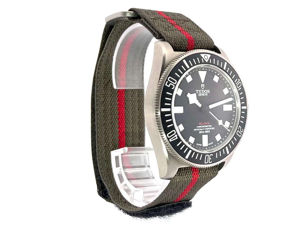 Tudor Pelagos FXD M25717N-0001 mit schwarzem Zifferblatt, titan Gehäuse, drehbarer Lünette, und grünem Textilband mit Klettschließe.